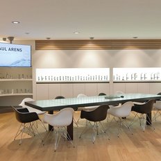 Der Raum zeigt eine stilvolle Einrichtung mit Holzfußboden, einem großen Tisch und einer Präsentation über Sanitärprodukte.