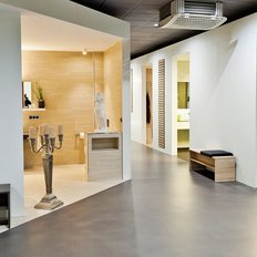 Ein moderner Raum mit eleganten Möbeln, einer Statue und einem großen Fenster, das viel Licht hereinlässt.