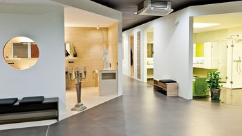 Ein moderner Raum mit eleganten Möbeln, einer Statue und einem großen Fenster, das viel Licht hereinlässt.